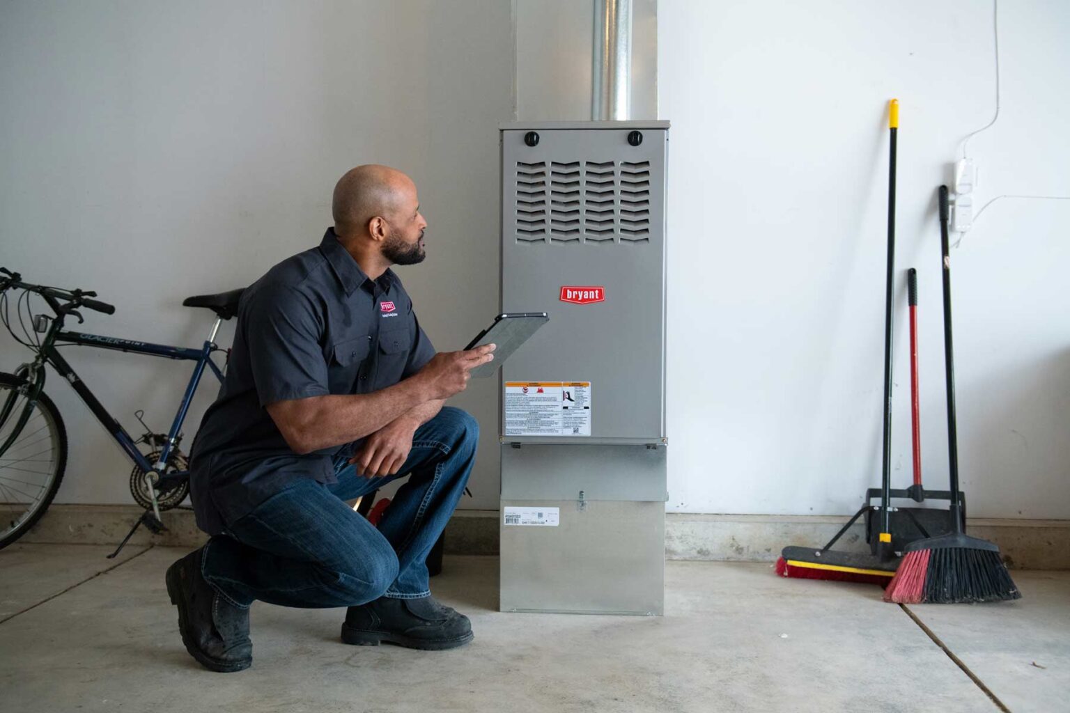 bryant dealer using ipad next to furnace