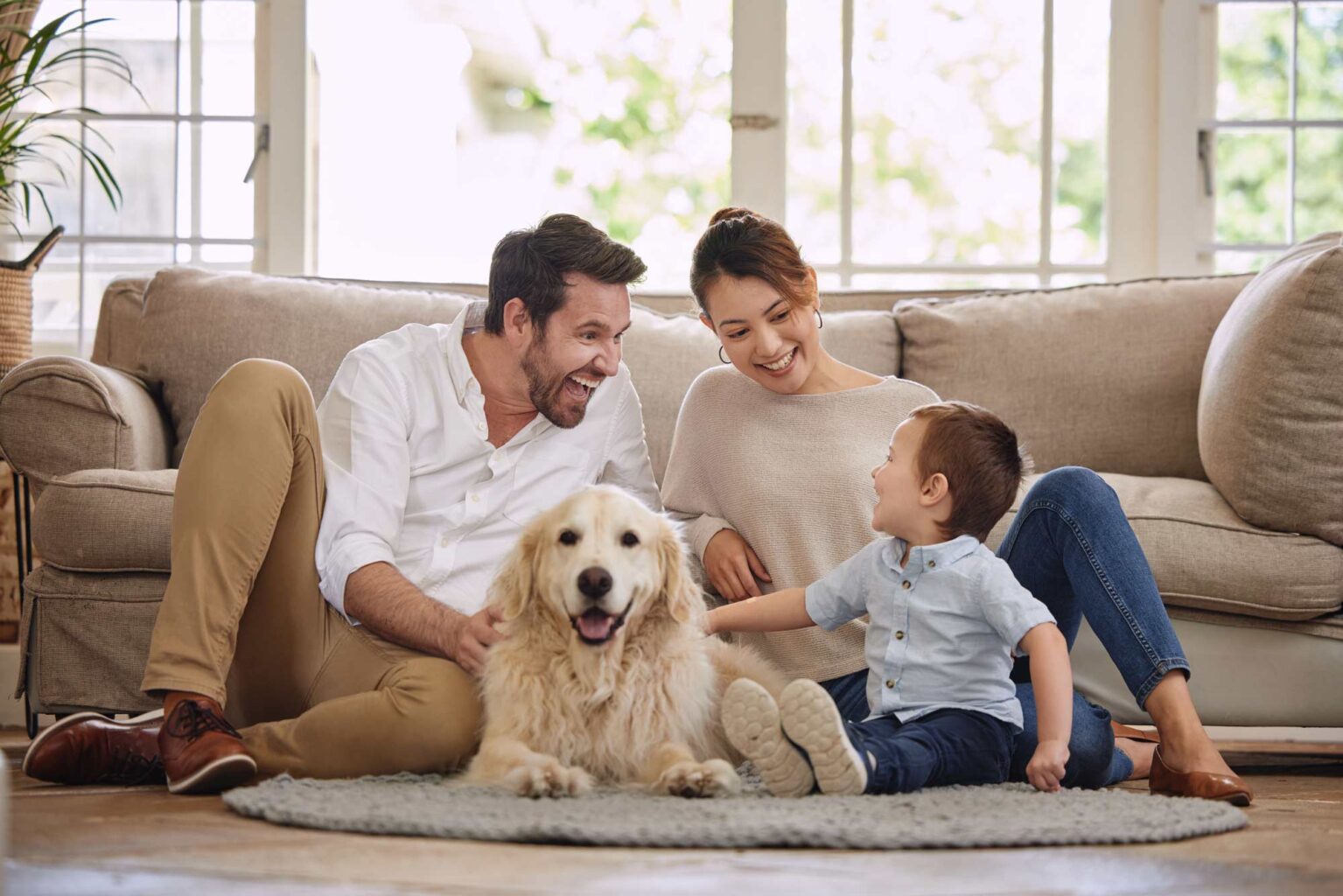 happy parents and kid lounging on the couch with dog