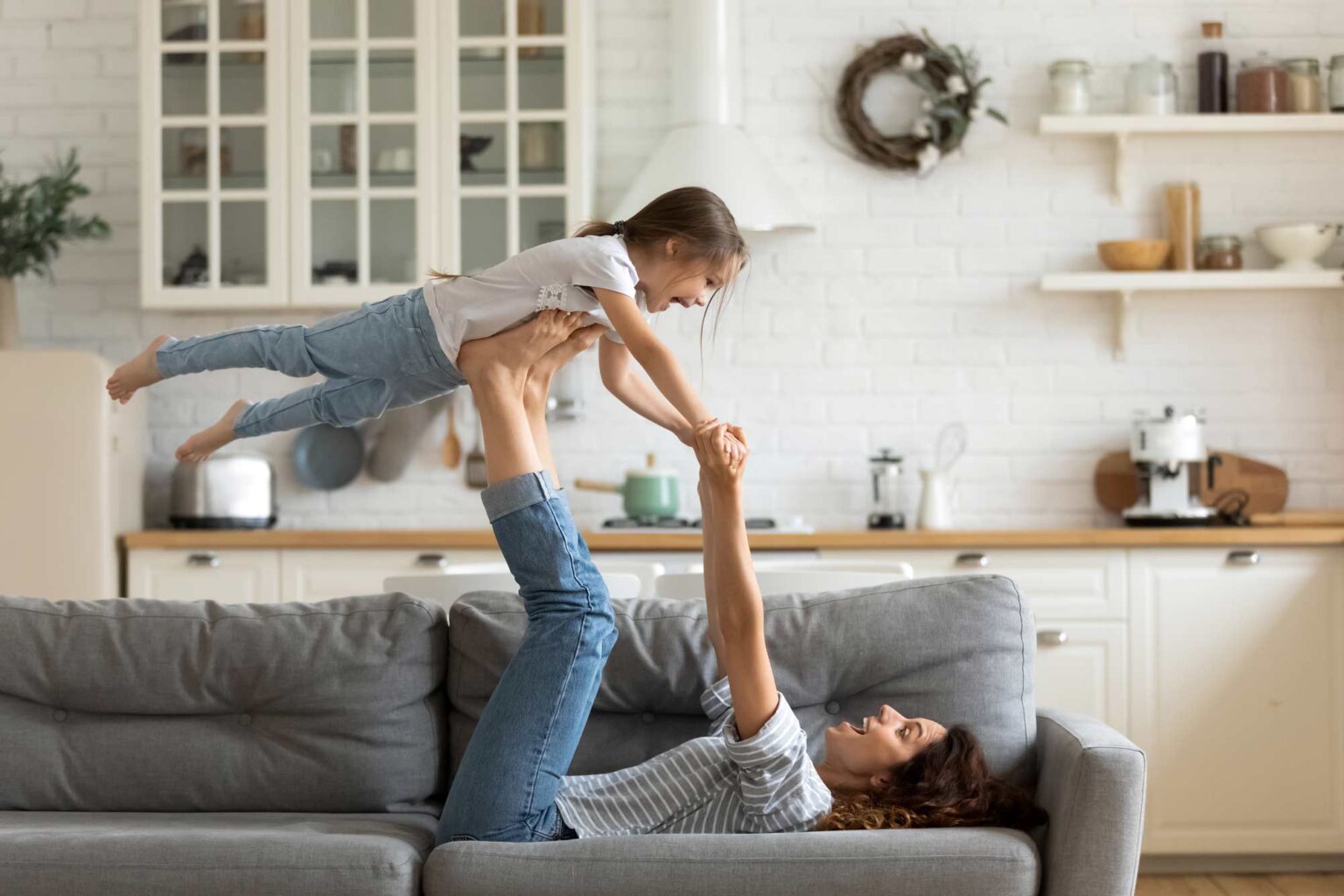 mom playing with daughter on couch